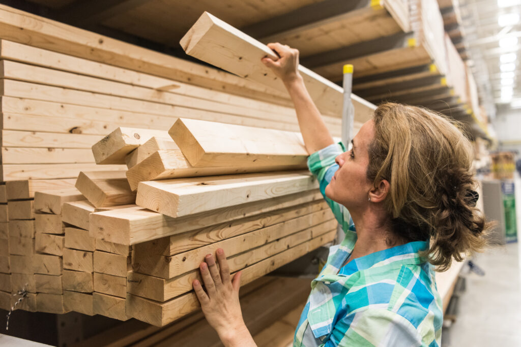 a woman taking a piece of a lumber in a store