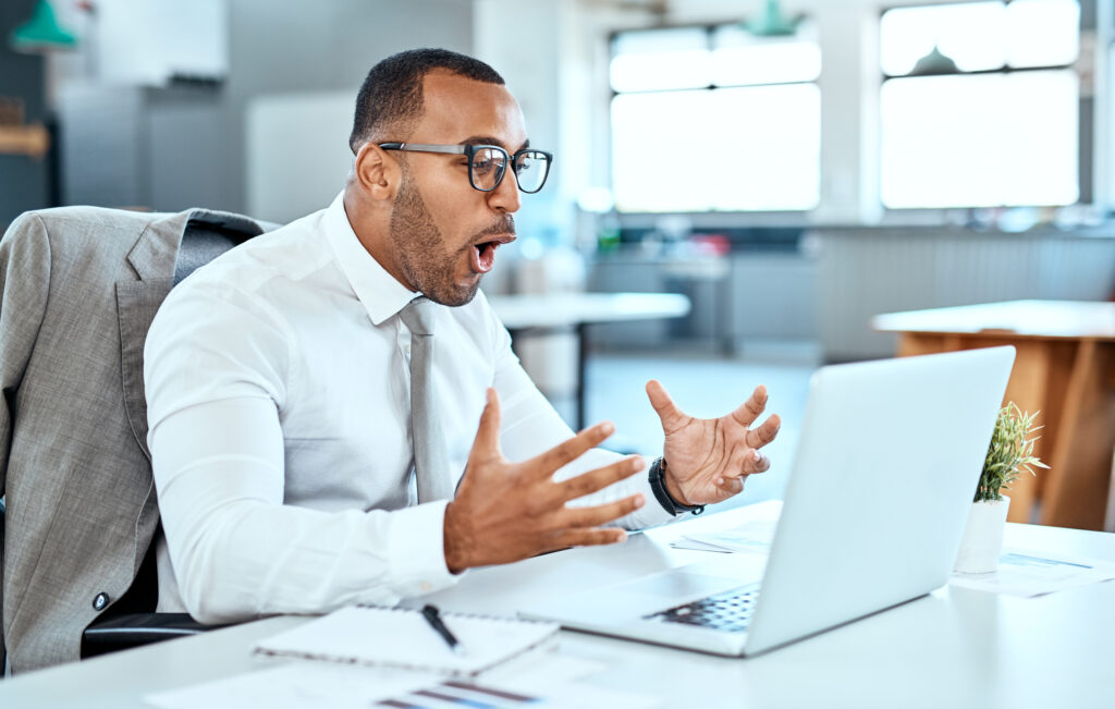 surprised and excited person looking at a laptop