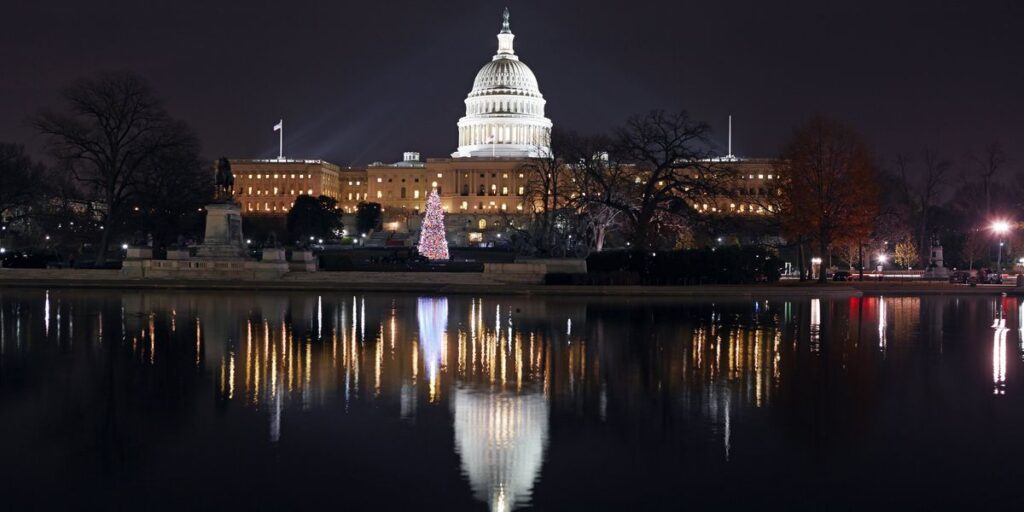 us capitol building at night with christmas tree and reflecting pool in foreground