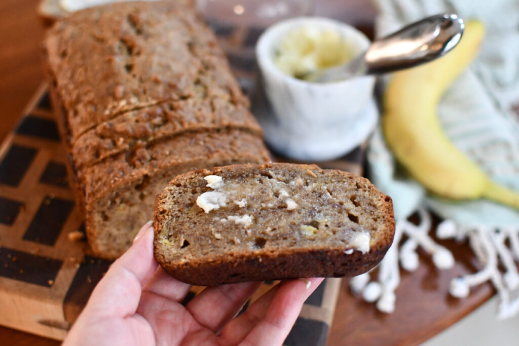 holding banana bread with butter 1