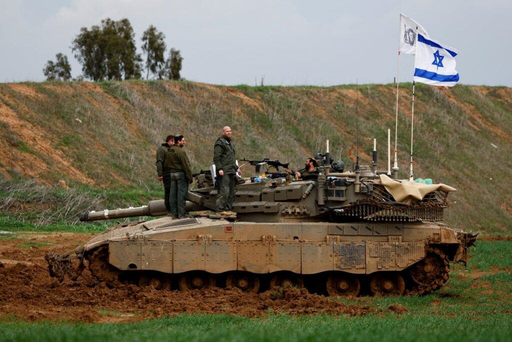 Israeli soldiers stand on a tank on the Israeli side of the border with Gaza 5yuxwv6o