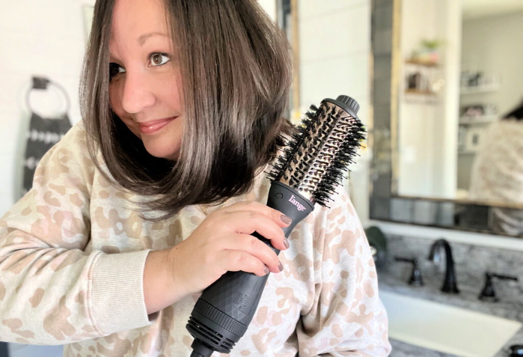 woman using lange hair dryer brush